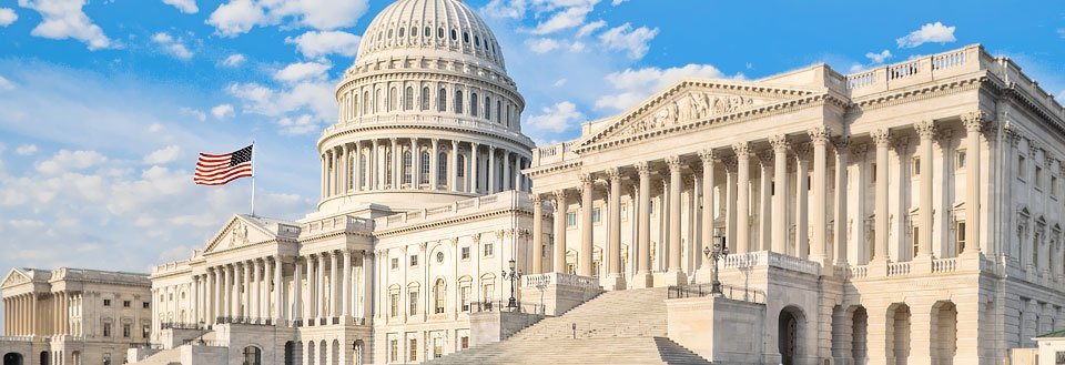 Capital med imponerende facade af en stor neoklassicistisk bygning under en blå himmel i Washington D.C.