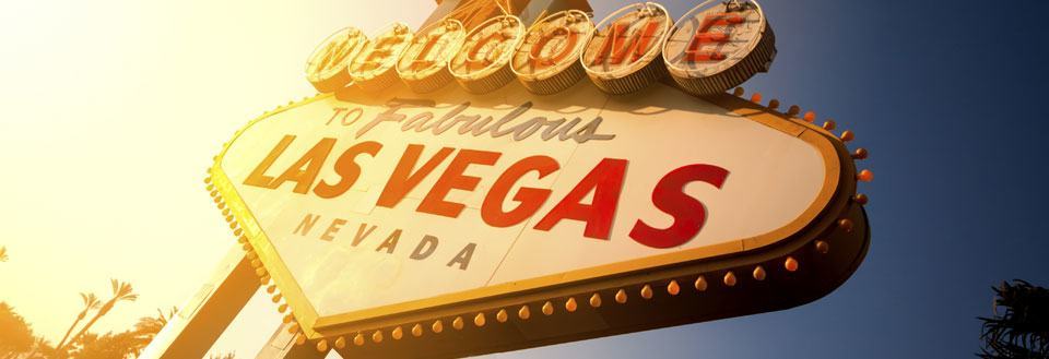 Billedet viser det ikoniske 'Welcome to Fabulous Las Vegas' skilt i oplyst solnedgang.