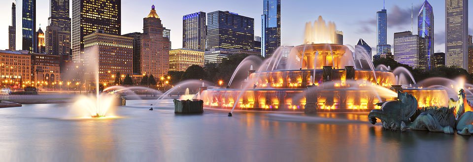Billede af en springvand med oplyste vandstråler ved skumring i Chicago.