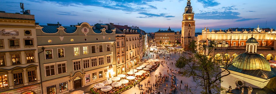 Den store markedsplads i Krakow, prydet med historiske bygninger, et mylder af mennesker og udendørs cafeer.