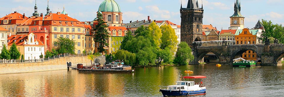 Smuk udsigt over en flod med en traditionel båd, omgivet af historiske bygninger og et ikonisk bro.