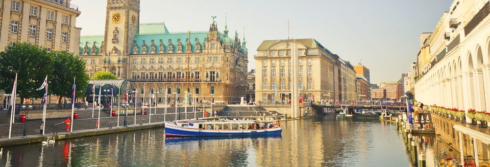 Spreee-floden i Berlin med både, omgivet af klassiske bygninger og flag.