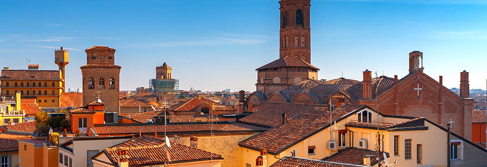 Bolognas horisont med tegltage og historiske tårne i solskinsvejr.