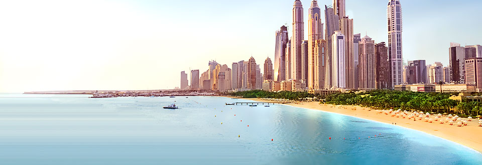 En panoramaudsigt over en moderne by ved kysten, med skyskrabere og en sandstrand foran et klart blåt hav.