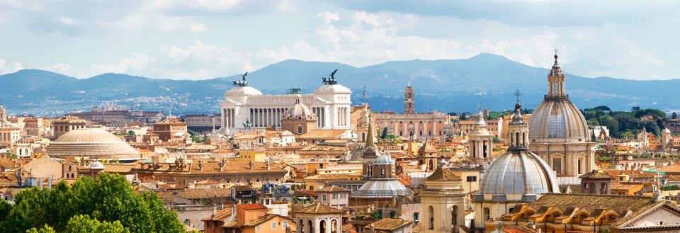 Rom's skyline med historiske bygninger og kupler under en skyet himmel.