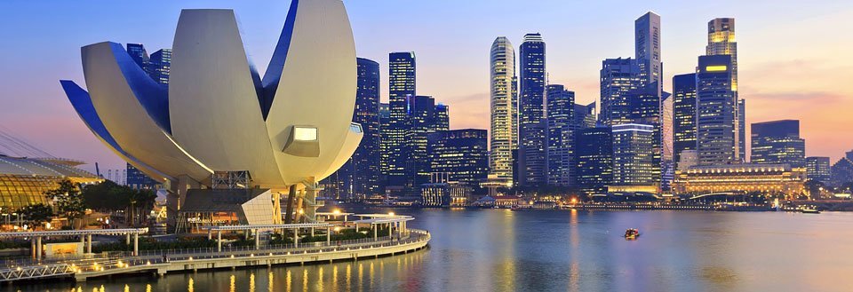 Singapore skyline ved solnedgang med ArtScience Museum i forgrunden ved marinaen.
