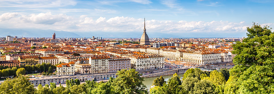 Panoramaudsigt over Torino med historiske bygninger og en flod der skærer igennem byen.