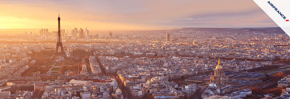 Billede af Paris' skyline ved solnedgang med Eiffeltårnet og byens tage.
