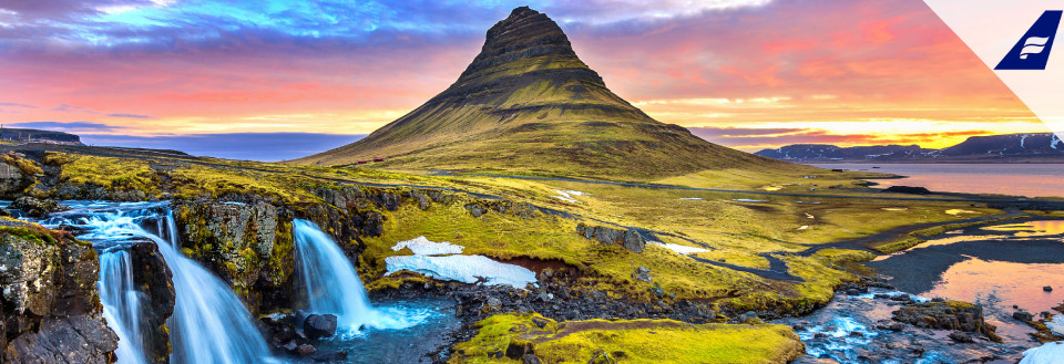 Kirkjufell bjerget i Island med et vandfald i forgrunden ved solnedgang.