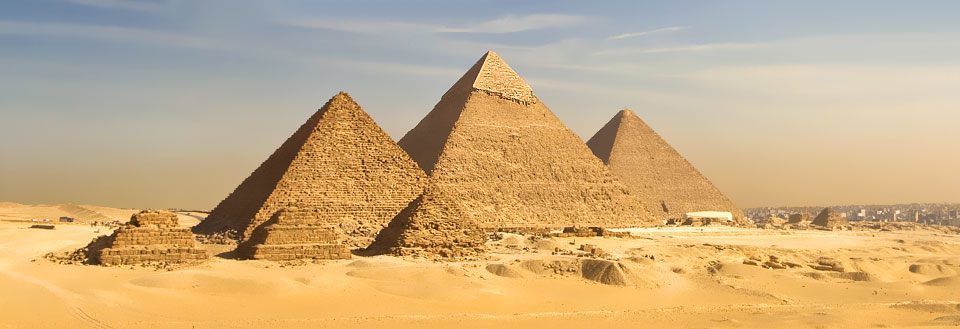 De imponerende pyramider i Giza under en klar himmel, omgivet af ørken.