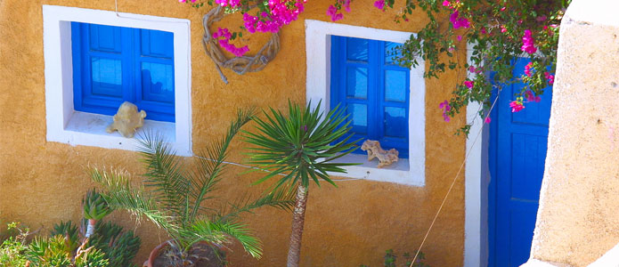 Charmerende bygning med blå vinduer og døre på Kreta