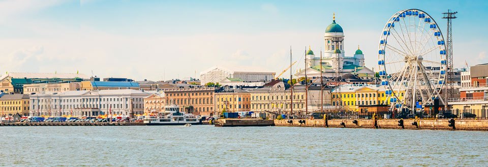 En havnefront med klassisk arkitektur og et pariserhjul. I baggrunden ses en dominerende kuppel.