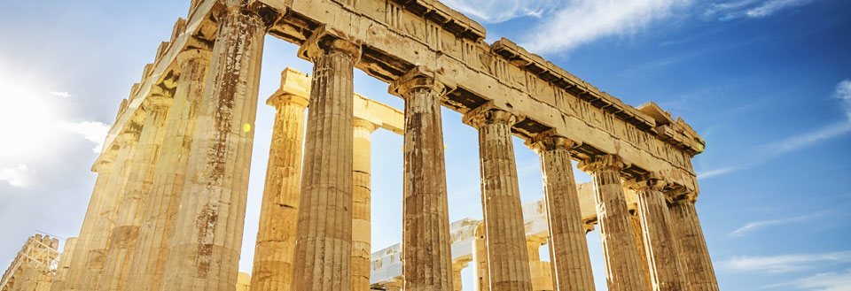 Billedet viser de majestætiske ruiner af Parthenon på Akropolis i Athen, badet i solens skær.