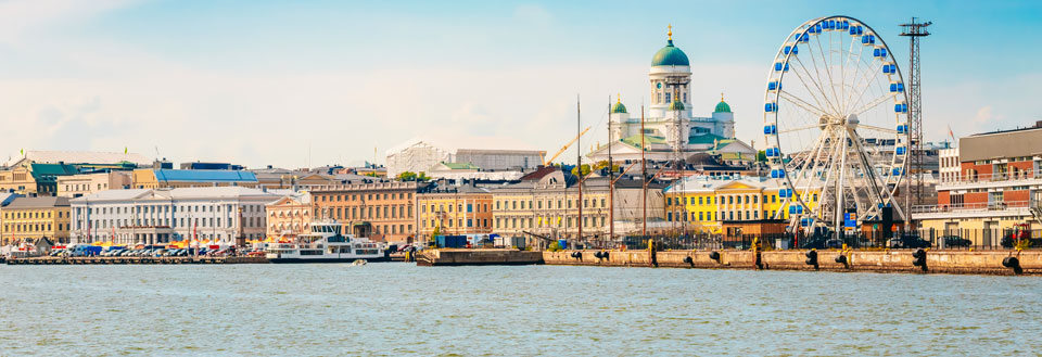 Havnefront med klassiske bygninger, en stor domkirke og et pariserhjul.