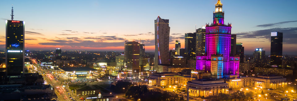 Warszawa med oplyste skyskrabere og travle gader.